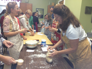 Rev. Ramerman joins a group in baking bread at a Spiritus retreat. Spiritus Christi’s pastor Rev. Mary Ramerman (right) is a leader in the church along with Father Jim Callan who together create a diverse and flourishing church community.