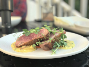 The seared duck breast is served rare with sweet roasted carrots and butternut squash polenta.