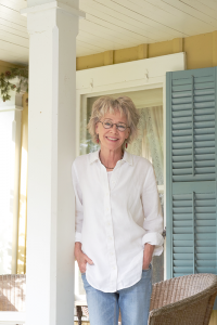 Gwenn Voelcker on the porch of her Mendon home.