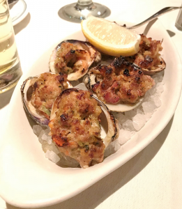 Six tender clams topped with a bread stuffing loaded with bacon, garlic and red pepper, served atop rock salt with a wedge of lemon.