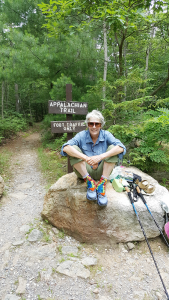 Sandy Wallace rests at a trail entrance.