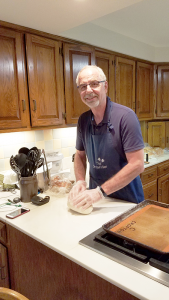 Hands on: Chet Fery in his kitchen in Brockport. He estimates he has baked nearly 100,000 loafs of bread to date — and given them away. Photo by Christine Green.
