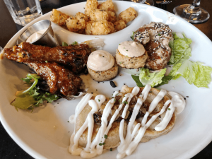 Sharing Platter: Edibles’ sharable sampler plate with five appetizers: duck, pierogi, salmon cakes, lunchbox shrimp and tots.