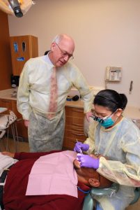 Dentist Bill Calnon supervises Dr. Maricelle Abayon, who at the time was a resident in one of Eastman Dental’s specialty training programs.