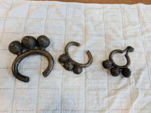 Manillas (slave bracelets, in brass) were the principal currency of the slave trade. European slavers, visiting the West African slave strongholds called barracoons, traded manillas and other goods for enslaved Africans. The approximate price: man at 35 manillas, a woman at 25 manillas, a teen-young adult at 15 manillas. Children had no value in this trade.