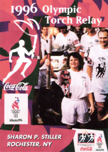 This poster features Sharon Stiller carrying the Olympic torch when it came through Rochester in 1996.