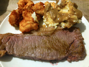 The “Land and Sea” option: a 12 oz New York strip steak, mashed potatoes, and three battered shrimp and scallops.