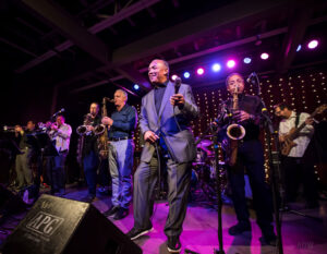 Prime Time Funk members are, from left, Derrick Lipp (trumpet), Ron D’Angelo (trumpet), Mike Edwards (baritone sax), Vince Ercolamento (tenor sax), Ronnie Leigh (vocalist), Jim Richmond (tenor sax), Ron France (bass). Out of frame are Andy Calabrese (keyboards) and David Cohen (drums). (Courtesy Aaron Winters)