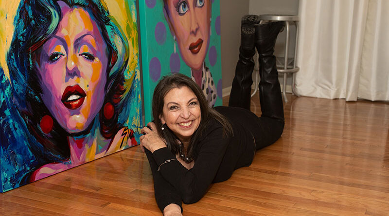 Photo by Michael Rivera. Lorraine Staunch with some of her portraits in her studio in Fairport.