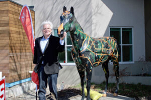 Howie Jacobson, who “energized” the idea of Horses on Parade in Rochester in 2001, stands with “Journey” at the Mid-Town Athletic Club. Artist Judith Olson Gregory created the design. Jacobson was chief marketing officer of the new High Falls Brewery, which birthed the project eventually leading to donations of $1.4 million to 114 charities. 
