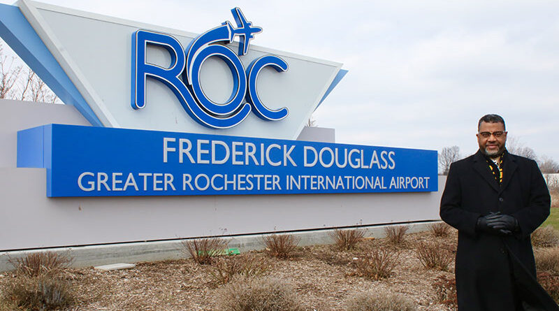 Rev. Julius Jackson Jr. and a sign of the renamed Rochester airport, now known as Frederick Douglass — Greater Rochester International Airport.